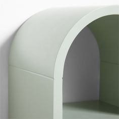 a white shelf with an arch on the top and bottom section in front of it