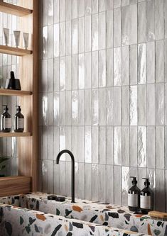 two sinks in a bathroom with tiled walls