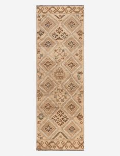 a beige and brown rug with an intricate design on the bottom, in front of a white background