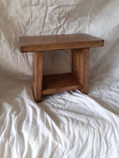 a wooden table sitting on top of a white sheet