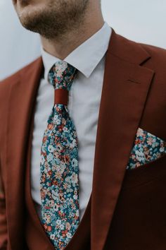 a man wearing a suit and tie with flowers on it