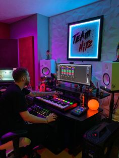 a man sitting at a desk in front of a computer monitor and sound mixing equipment