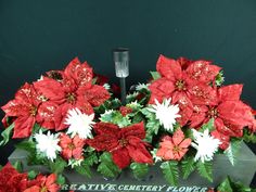 poinsettis and other flowers are arranged in a display case on a table