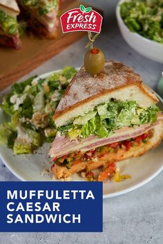 a plate with a sandwich cut in half on top of it next to a salad