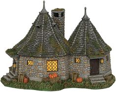 an image of a small house that is made out of stone and has pumpkins on the lawn