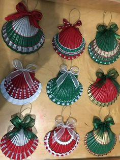 christmas ornaments are hanging from the ceiling in different colors and patterns, with bows on each ornament