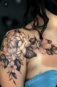 a woman wearing a blue dress with flowers on her chest and shoulder tattoo design in black ink