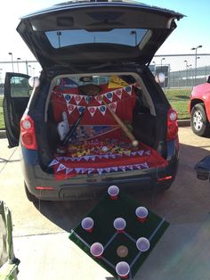 the trunk of a car is filled with drinks and decorations for a game day party