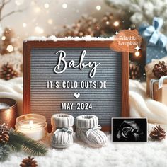 a baby it's cold outside sign surrounded by christmas decorations and candles with presents in the background