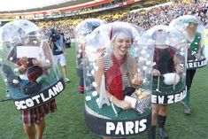 some people are standing in fake bubbles at a soccer game