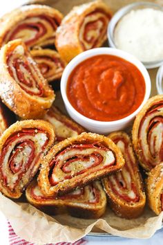 several pastries are arranged on a plate with dipping sauce