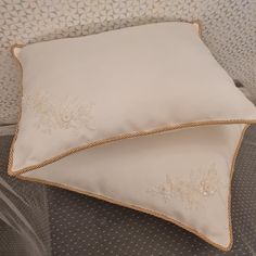 two white pillows sitting next to each other on a bed