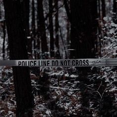 a police line do not cross sign in the woods