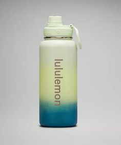 a blue and yellow water bottle sitting on top of a white table next to a gray wall