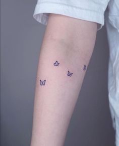 a woman's leg with small butterflies on the left side of her arm,