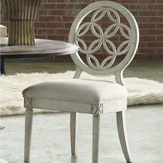 a white chair sitting on top of a floor next to a wooden table and chairs