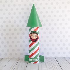 a paper tube with a elf's head sticking out of it