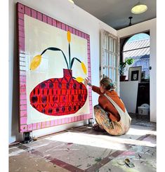 a woman is painting on the wall in her home