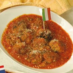 a white plate topped with meatballs covered in sauce