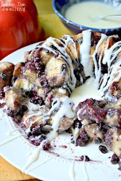 a bundt cake covered in blueberries and drizzled with icing