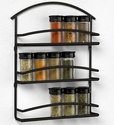 an image of spice rack with spices on the top and bottom shelves in black metal