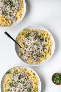 three white bowls filled with pasta and sauce