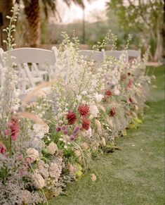 rows of chairs lined up with flowers and greenery