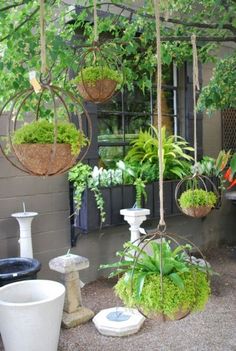 several hanging planters filled with plants in front of a building