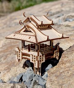 a small wooden structure sitting on top of a rock