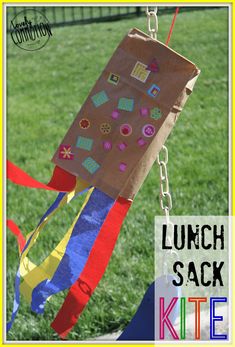 a paper bag hanging from a chain in the grass with text overlay that says lunch