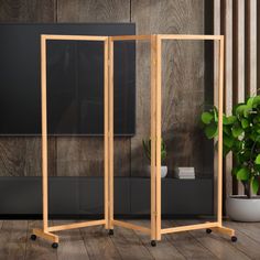 a wooden room divider in front of a plant