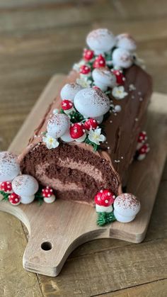 a piece of chocolate cake on a cutting board with flowers and berries all over it