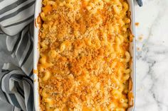 a casserole dish with macaroni and cheese in it on a marble surface