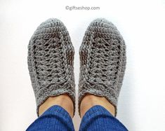 someone is wearing crocheted slippers with their feet up on the floor and they are standing in front of a white wall