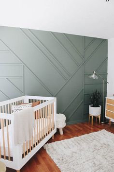 a baby's room with two cribs and an accent wall from basi