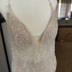 a wedding dress on display at a bridal shop in the evening hours, with its beading and sequins