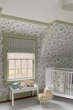 a baby's room with floral wallpaper and white crib in the corner