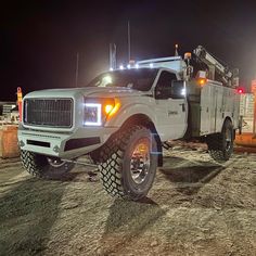 a large white truck parked on top of a dirt field