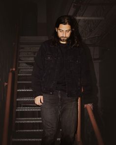 a man with long hair and beard standing on stairs