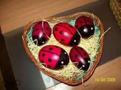 four red and black ladybugs sitting in a basket on top of a table