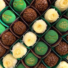 several green and white cupcakes are arranged in small trays with frosting on them