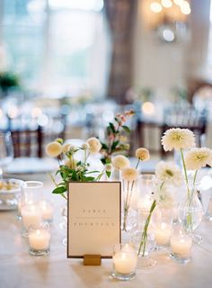 a table topped with lots of white flowers and candles