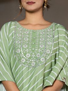 This 2-piece set includes green embroidery & leheriya print kaftan style kurta has round neck, short flared sleeves, flared hem, calf length teamed with solid trouser pants with elasticated waistband & slip on closure. 2 Piece Set Color-Green Kurta Fabric- Silk Blend Work - Thread Work Embroidery & Leheriya Print Detailing Neck - Round Neck Sleeves - Short Flared Sleeves Length-Calf Length Pocket - Single Pocket Bottom - Solid Trouser Pants Size & Fit - Elasticated Waistband Bottom - Slip-on Closure Washing Care-Hand Wash The model height 5'8 is wearing a size small Green Straight Kurta Set With Mirror Work, Anarkali Sets With Mirror Work For Spring, Spring Anarkali Sets With Mirror Work, Spring Straight Kurta Set With Gota Work, Green Mirror Work Salwar Kameez For Spring, Green Gota Work Sets For Summer, Spring Sets With Gota Work And Straight Kurta, Spring Green Salwar Kameez With Mirror Work, Green Salwar Kameez With Mirror Work For Spring