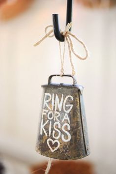 a ring for a kiss hanging from a string with the words ring for a kiss written on it