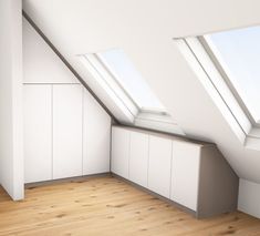 an empty room with two skylights above the windows and cupboards on the wall