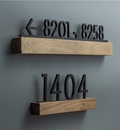 two wooden shelves with metal numbers and arrows on each shelf, one has the number forty four