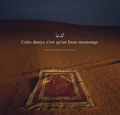 an image of a rug in the middle of sand with arabic writing on it that reads,