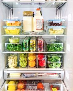 an open refrigerator filled with lots of different types of vegetables and fruit in containers on the shelves