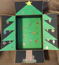 a cardboard christmas tree with ornaments in the bottom and on the inside, is shown