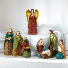 a group of figurines sitting on top of a white shelf next to each other